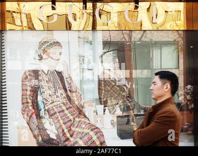 Ein Fußgänger geht durch die Boutique von Gucci in einem Einkaufszentrum in Hangzhou Ctiy, der ostchinesischen Provinz Zhejiang am 12. Dezember, 2019. Stockfoto