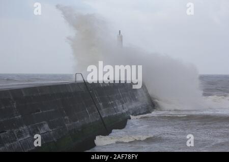 Aberystwyth Wales UK Wetter 13. Dezember 2019, ein stürmischer Tag an der walisischen Küste, wo stong in der Nähe von Gale force Wind treibt in riesigen Wellen, die Teig das Meer Abwehr und Crash über den Hafen Licht während der Flut: credit Mike Davies/Alamy leben Nachrichten Stockfoto