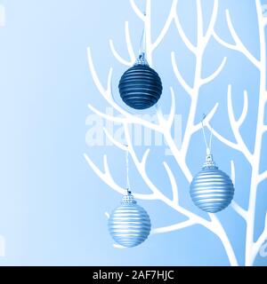 Weihnachtsbaum aus weißem Kunststoff Hörner und Christbaumkugel Dekoration auf dem Blauen Stockfoto