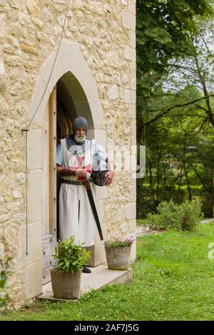 Outdoor Pose eines Mannes in authentischen Templer Outfit oder kreuzritter Kostüm stehen vor dem Hintergrund eines mittelalterlichen französischen Schloss gekleidet Stockfoto