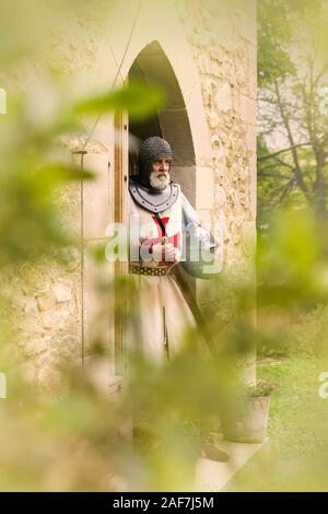 Outdoor Pose eines Mannes in authentischen Templer Outfit oder kreuzritter Kostüm stehen vor dem Hintergrund eines mittelalterlichen französischen Schloss gekleidet Stockfoto