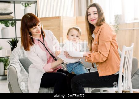 Freundliche junge Frau Kinderarzt Arzt Gespräche mit der Mutter der kleinen Mädchen nach Prüfung. Stockfoto