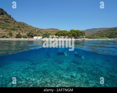 Spanien, Strand Küste im Sommer Urlaub mit Taucher unterwasser, geteilte Ansicht oberhalb und unterhalb der Wasseroberfläche, Mittelmeer, Costa Brava Stockfoto