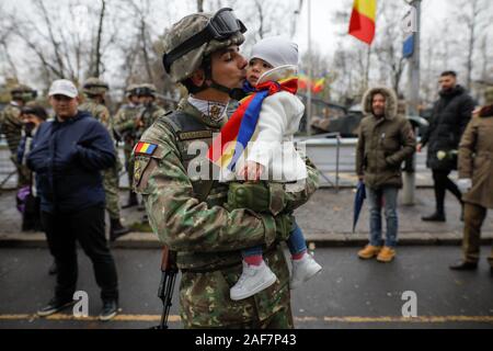 Bukarest, Rumänien - Dezember 01, 2019: Die rumänische Armee Soldat hält sein Kind in die Arme während der rumänischen nationalen Tag militärische Parade. Stockfoto