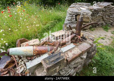 Sortierte rusty shell Fällen und Granatsplittern verwendet eine Wand in das verlassene Dorf Tyneham, Dorset, England, UK zu bauen Stockfoto