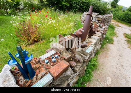 Sortierte rusty shell Fällen und Granatsplittern verwendet eine Wand in das verlassene Dorf Tyneham, Dorset, England, UK zu bauen Stockfoto