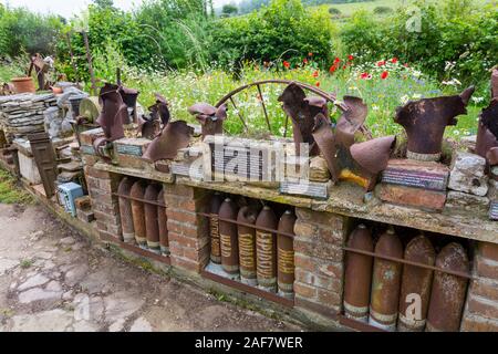 Sortierte rusty shell Fällen und Granatsplittern verwendet eine Wand in das verlassene Dorf Tyneham, Dorset, England, UK zu bauen Stockfoto