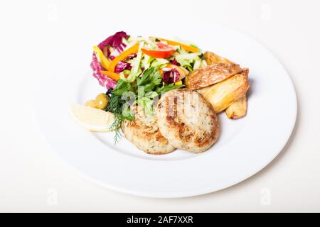 Gebratener Fisch Koteletts mit Rohkostsalat und gegrillte Kartoffeln Stockfoto