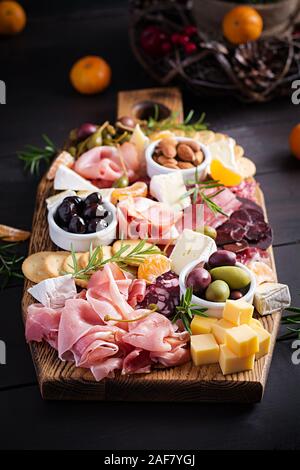 Antipasti Teller mit Schinken, Prosciutto, Salami, Käse, Cracker und Oliven auf einer hölzernen Hintergrund. Weihnachten Tabelle. Stockfoto