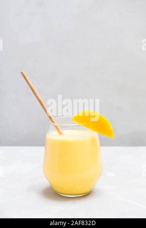 Mango Lassi in einem Glas Schale auf neutralen grauen Hintergrund mit Kopie Raum Stockfoto