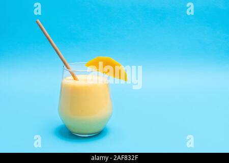 Traditionelle indische drink Mango Lassi mit Gewürzen in einem Glas Schale auf blauem Hintergrund mit Kopie Raum Stockfoto