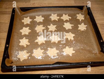 Sternförmige Weihnachtsplätzchen in einem Ofen Fach vor dem Backen Stockfoto