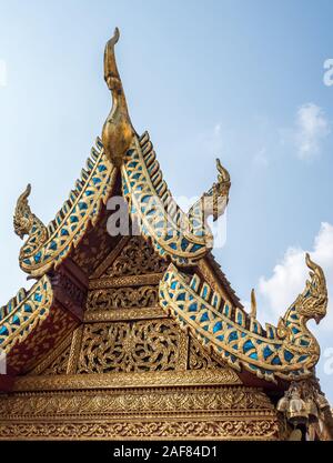 Geschnitzte florale Muster im traditionellen thailändischen Stil auf dem Giebel der thailändischen Kirche, die mit dem Drachen Kopf Figuren dekoriert (öffentlicher Bereich nicht re Stockfoto