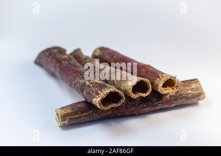 Natürliche gesunde getrocknete Leckereien für Hunde. Rindfleisch Speiseröhre auf einem hellen Hintergrund. Köstliche Leckereien für Haustiere. Stockfoto