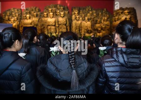 (191213) - Peking, Dez. 13, 2019 (Xinhua) - Studierende bereiten Sie Blumen zu Märtyrer während einer Ausstellung an der Tokioter Prozess im Museum für den Krieg der Chinesen, der Widerstand gegen die japanische Aggression in Peking, der Hauptstadt von China, Dez. 13, 2019 präsentieren. Vor der Masse in Schwarz, Chinas nationale Flagge flog auf Halbmast als die Nation einer Trauerfeier Freitag statt der 300.000 Opfer des Massakers von Nanjing zu trauern. (Xinhua / Peng Ziyang) Stockfoto