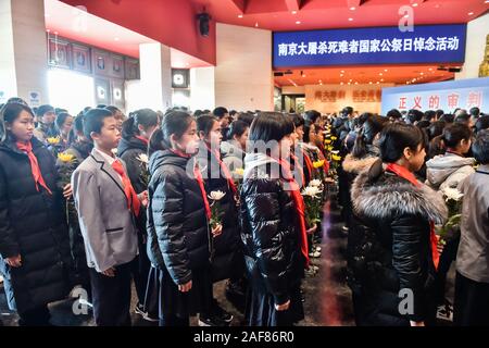 (191213) - Peking, Dez. 13, 2019 (Xinhua) - Studierende bereiten Sie Blumen zu Märtyrer während einer Ausstellung an der Tokioter Prozess im Museum für den Krieg der Chinesen, der Widerstand gegen die japanische Aggression in Peking, der Hauptstadt von China, Dez. 13, 2019 präsentieren. Vor der Masse in Schwarz, Chinas nationale Flagge flog auf Halbmast als die Nation einer Trauerfeier Freitag statt der 300.000 Opfer des Massakers von Nanjing zu trauern. (Xinhua / Peng Ziyang) Stockfoto