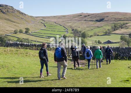 Eine Gruppe von Wanderern auf dem kreisförmigen Pfad um Malham Cove und Gordale Scar in den Yorkshire Dales National Park Stockfoto