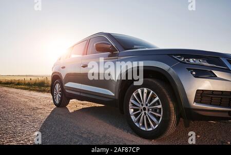 Sonnenlicht geht über Automobil. Modernes neues Auto auf der Straße in die Landschaft am Tag geparkt Stockfoto