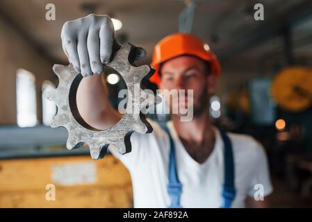 Hält in einer Hand. Mann in Uniform Werke auf die Produktion. Die industrielle moderne Technologie Stockfoto