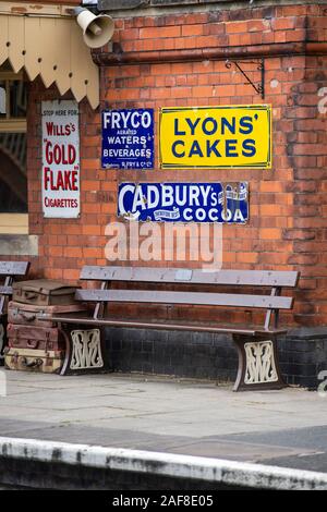 Alte Werbeschilder auf einer Plattform an das Erbe Bahnhof in Toddington, Gloucestershire, England, Großbritannien Stockfoto