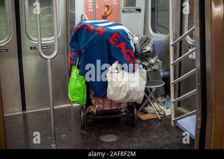 Eine obdachlose Person schläft auf einer U-Bahn in New York am Sonntag, 8. Dezember 2019. (© Richard B. Levine) Stockfoto