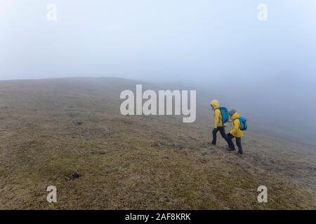 Mutter und Sohn zu Fuß auf Wanderung in nebligen Berge Natur Landschaft in den slowenischen Alpen. sportliche Wanderer auf Trek mit Rucksack Leben gesunder Lebensstil Stockfoto