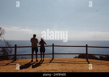 Zwei Touristen ein Kerl und ein Mädchen stehen mit dem Rücken zum Meer aus großer Höhe. Ein Foto für Speicher. Spanien Stockfoto