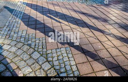 Die Schatten von Menschen in einem Einkaufszentrum auf einer gepflasterten Boden Stockfoto