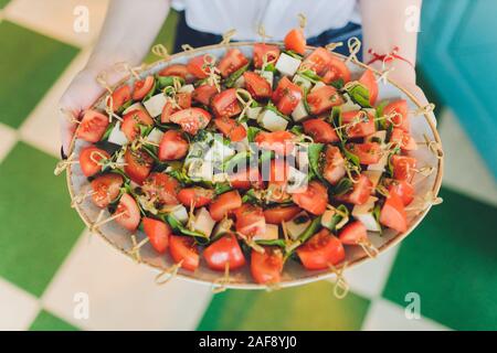 Close-up große Platte mit servieren Snacks canapes frittiertes Brot Tomate Petersilie und Salami Stockfoto