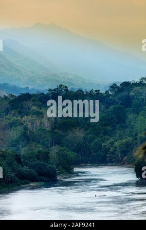 Ein Holzkanu, das den Fluss Sadang mit den Bergen Rantekombola und Latimojongin in Tana Toraja hinter Sulawesi, Indones überquert Stockfoto