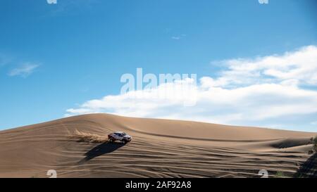 toyota hilux dakar Rallye Edition Spritzstaub beim Klettern einer Sanddüne in Dasht e lut oder sahara Wüste, ADS Raum Stockfoto