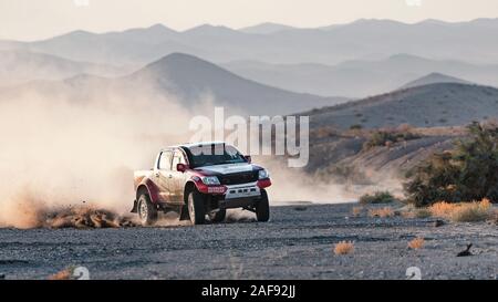 zahedan, baluchestan-iran- juli 27 2021 toyota Hulux dakar Rallye-Edition sprang in die Luft und spritzte Staub zurück bei Sonnenuntergang in Dasht e lut Wüste Stockfoto