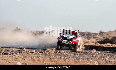 zahedan, baluchestan-iran- juli 27 2021 toyota Hulux dakar Rallye-Edition sprang in die Luft und spritzte Staub zurück bei Sonnenuntergang in Dasht e lut Wüste Stockfoto