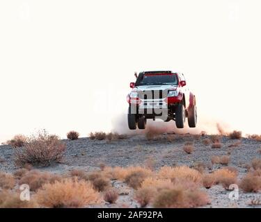 zahedan, baluchestan-iran- juli 27 2021 toyota Hulux dakar Rallye-Edition sprang in die Luft und spritzte Staub zurück bei Sonnenuntergang in Dasht e lut Wüste Stockfoto