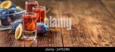 Hausgemachte Pflaume Likör auf einem holztisch als detaillierte Nahaufnahme; selektive Fokus Stockfoto