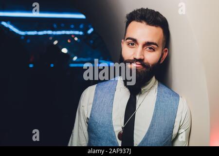 Arabischer Mann Junge in einer Jacke steht in einem Club Stockfoto