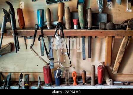 Meißel, Hammer, und andere Tools hängen in die Holzwand Stockfoto