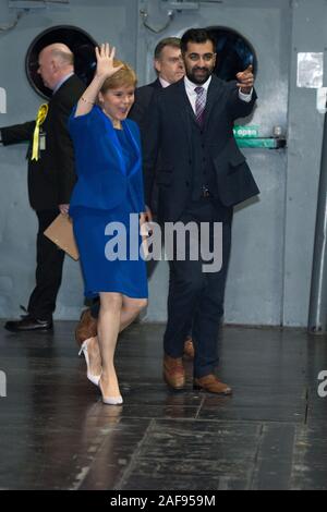 Glasgow, UK. 13. Dezember 2019. Im Bild: (in Blau) Nicola Sturgeon MSP - Erster Minister von Schottland und Leiter der Scottish National Party (SNP); (rechts), Humza Yousaf MSP-Justizminister. Szenen aus der Auszählung der Stimmen bei den Schottischen Ausstellungs- und Konferenzzentrum (SECC). Die Polen haben jetzt geschlossen um 22 Uhr an und die Auszählung der Stimmen ist jetzt unterwegs für den britischen Parlamentarischen Wahlen 2019. Dies ist das erste Mal in fast 100 Jahren, dass eine allgemeine Wahl im Dezember stattgefunden hat. Stockfoto