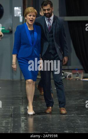 Glasgow, UK. 13. Dezember 2019. Im Bild: (in Blau) Nicola Sturgeon MSP - Erster Minister von Schottland und Leiter der Scottish National Party (SNP); (rechts), Humza Yousaf MSP-Justizminister. Szenen aus der Auszählung der Stimmen bei den Schottischen Ausstellungs- und Konferenzzentrum (SECC). Die Polen haben jetzt geschlossen um 22 Uhr an und die Auszählung der Stimmen ist jetzt unterwegs für den britischen Parlamentarischen Wahlen 2019. Dies ist das erste Mal in fast 100 Jahren, dass eine allgemeine Wahl im Dezember stattgefunden hat. Stockfoto