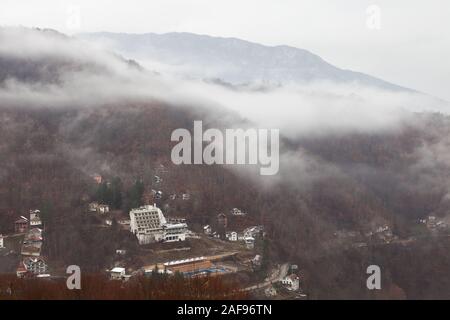 Alten, verlassenen, verfallenen Gebäude, Villen und Häusern neben der Straße in der Misty Mountain durch bunte rote Bäume Stockfoto