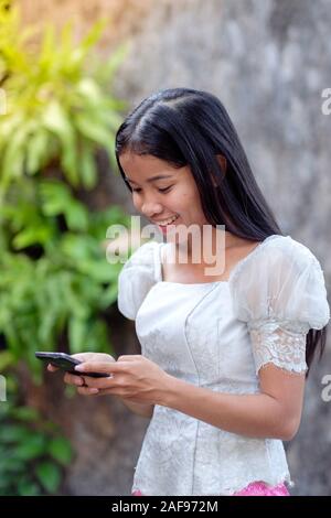 Ein junger Khmer (Kambodschanisch) Frau mit ihrem Mobiltelefon in Kambodscha Stockfoto