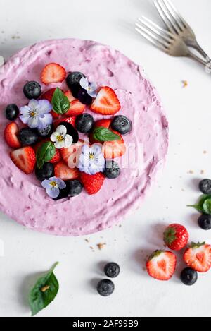 Sommer Berry Käsekuchen mit Erdbeeren, Heidelbeeren und Stiefmütterchen Stockfoto