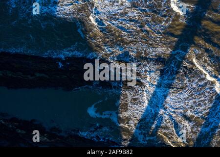 Wellen schlagen gegen die felsige Küste von St Andrews Scotland. Perfektes abstraktes Hintergrundbild. Stockfoto