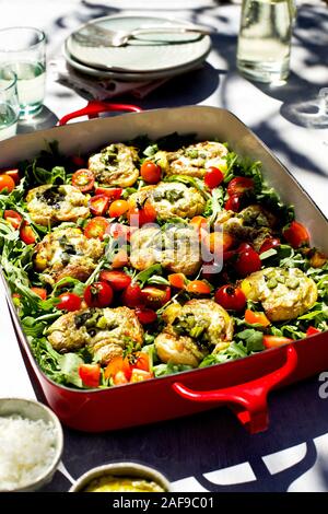 Roasted Poblano Pesto zertrümmerte Kartoffeln serviert auf einem Bett von Rucola und Tomaten Stockfoto