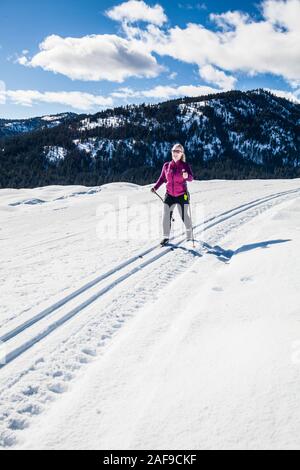 Eine Frau Langlaufen auf den Loipen in der Nähe von Sun Mountain Lodge in der Methow Valley, Washington State, USA. Stockfoto