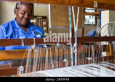 Arusha, Tansania. Frau Arbeiten an Ihrem Webstuhl in Shanga, einem Zentrum für Kunsthandwerk Beschäftigung von Behinderten. Stockfoto
