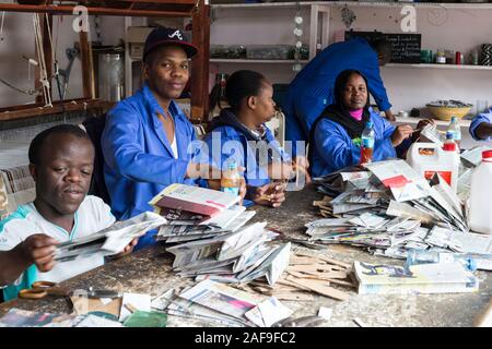 Arusha, Tansania. Arbeitnehmer Taschen aus recycelten Zeitungen auf Shanga, einem Zentrum für Kunsthandwerk Beschäftigung von Behinderten. Stockfoto
