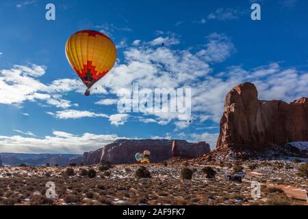 Heißluftballone fliegen im Monument Valley Ballon Festival im Monument Valley Navajo Tribal Park in Arizona. Camel Butte ist auf der rechten Seite. Stockfoto