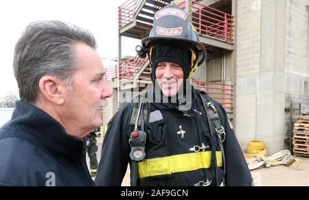 St. Louis, USA. 13 Dez, 2019. Fernsehen host des A&E zeigen "Leben retten" Matt gesagtes Iseman, (R) Gespräche mit St. Louis Fire Chief Dennis Jenkerson, bevor Sie eine Live Brennen mit dem St. Louis Feuerwehr in St. Louis am Freitag, 13. Dezember 2019. Gesagtes Iseman, am Besten als der Wirt des 'American Ninja Warrior' gekleidet in voller Brandbekämpfung Gang zu erleben und ein echtes Feuer löschen, seine erste. Foto von Bill Greenblatt/UPI Quelle: UPI/Alamy leben Nachrichten Stockfoto