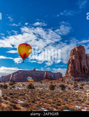 Heißluftballone fliegen im Monument Valley Ballon Festival im Monument Valley Navajo Tribal Park in Arizona. Camel Butte ist auf der rechten Seite. Stockfoto